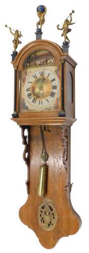 A 20thC Continental wall clock, the arched hood surmounted by cast metal figures, above a 24cm...
