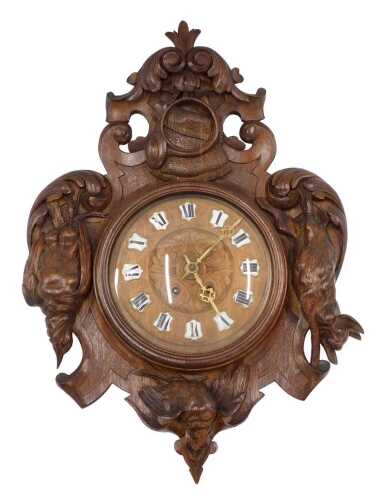 A heavily carved early 20thC oak Black Forest wall clock, the 24cm diameter dial, with raised...