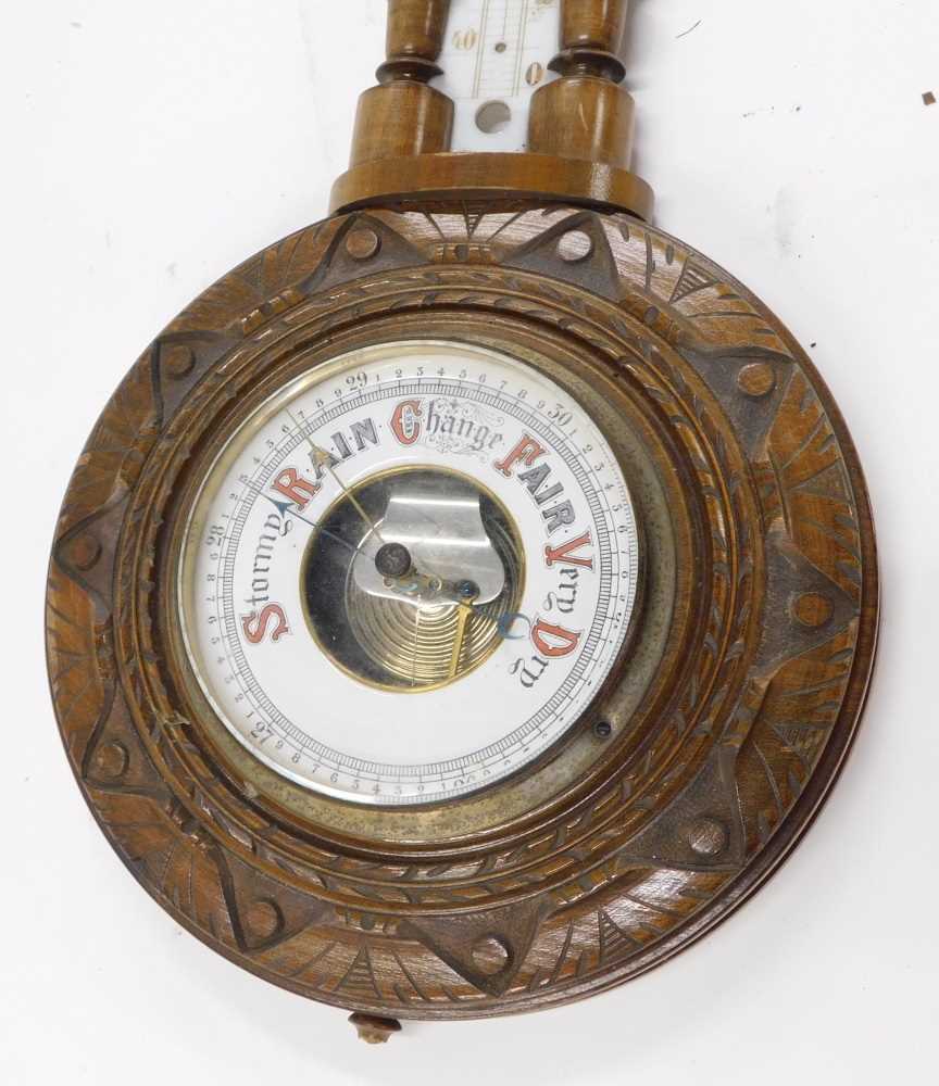 An early 20thC walnut cased wheel barometer and thermometer, in a ...