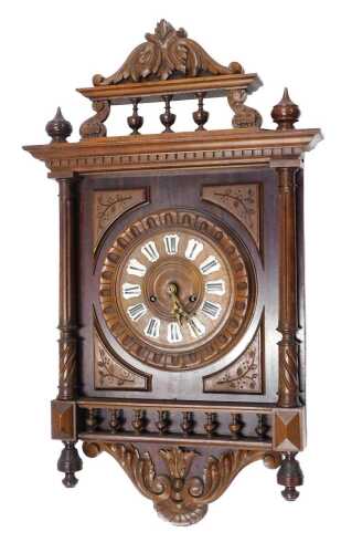 A late 19thC walnut cased wall clock, the heavily carved 22cm diameter dial with raised enamel...