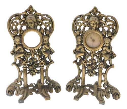 A pair of early 20thC brass table clock stands, each of rococo style with masks and pierced...