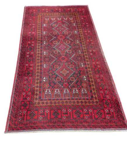 A 20thC Afghan Baluch style rug, of rectangular form, the outer border with a geometric banding,...