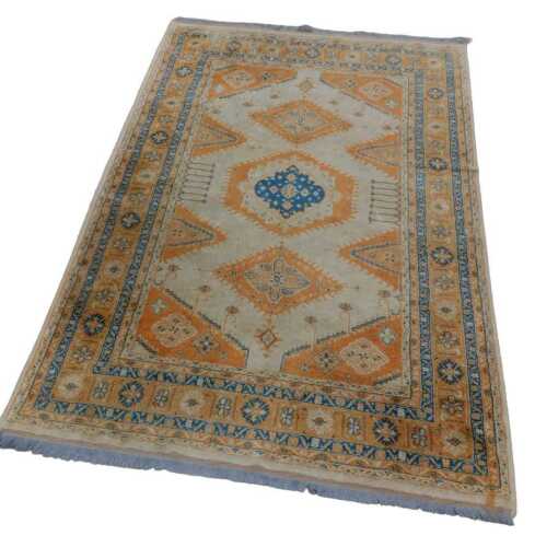 A 20thC rug, possibly Turkish, of rectangular form, the outer border with a floral pattern, the...