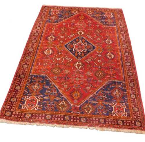 A 20thC Iranian Qashqai style carpet, the outer border with a floral repeat geometric pattern,...
