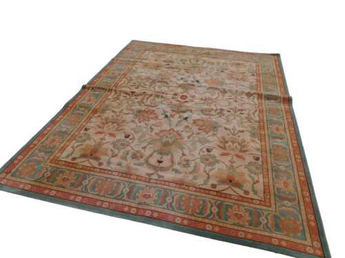 A large Chinese rectangular rug, the outer border with a floral pattern on a green and orange...