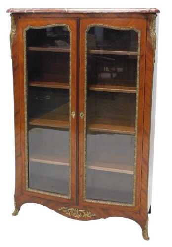 A Louis XVI style kingwood display cabinet, with marble top raised above two glazed doors with...