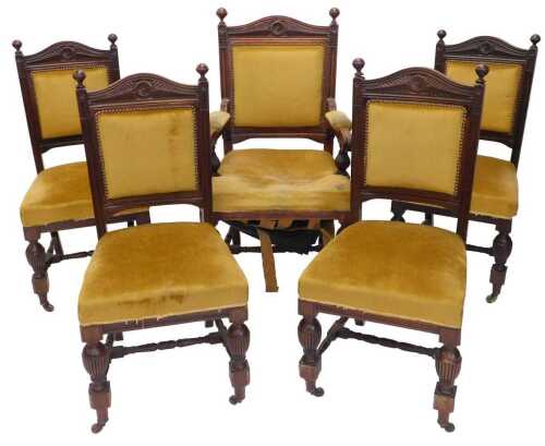 A set of five late Victorian walnut dining chairs, the carver with shaped top above an...