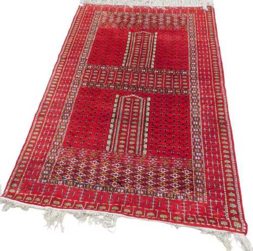 A rectangular hearth rug, possibly Turkish, geometric pattern on a red ground, 193cm x 131cm.