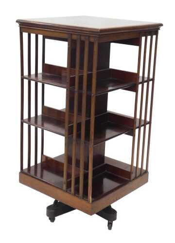 An Edwardian mahogany rotating bookcase, of large proportion, the square top raised above an...