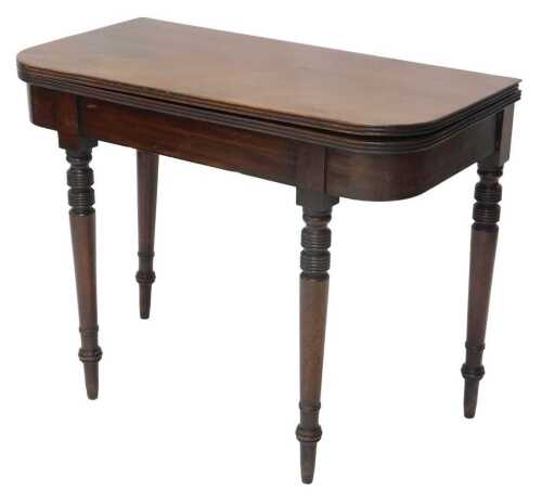A 19thC mahogany fold over tea table, the D end top raised on turned cylindrical legs, when...