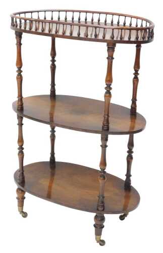 A late Victorian etagere or whatnot, of oval form, with galleried top raised on baluster columns,...