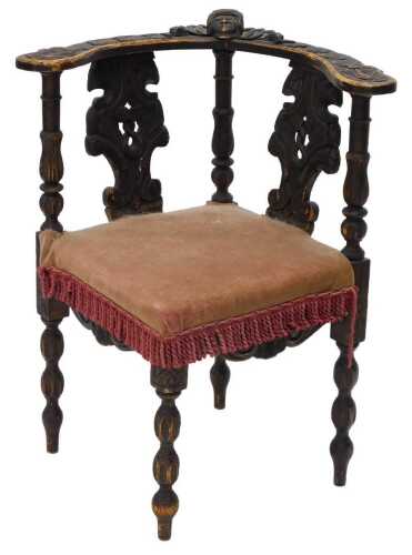 A 19thC rustic oak corner chair, heavily carved with figure heads and scrolls, with baluster...