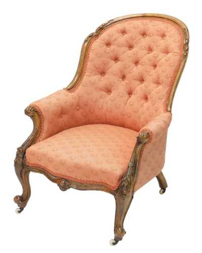 A Victorian walnut show frame armchair, with overstuffed studded back and arms, and serpentine...