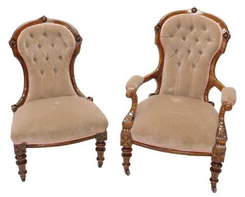 A pair of ladies and gentlemen's Victorian walnut show frame armchairs, each with floral carved...