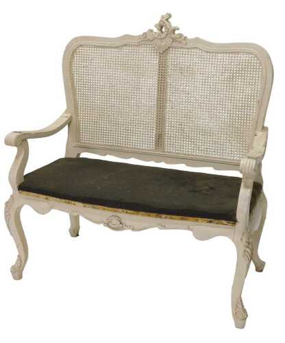 A 20thC wooden bergere backed two seater salon sofa, surmounted by a scroll and shell carving,...
