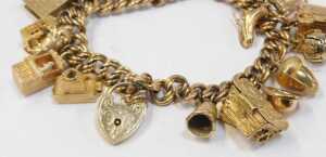 A 9ct gold charm bracelet, the double curb link bracelet with a heart shaped padlock and safety... - 2