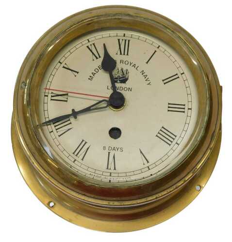 A brass cased ship's clock, the circular dial bearing Roman numerals and Made for Royal Navy...
