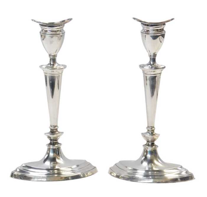 A pair of Edward VII loaded silver candlesticks, of slender tapering form, raised on an oval...