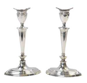 A pair of Edward VII loaded silver candlesticks, of slender tapering form, raised on an oval...