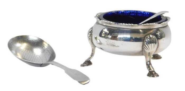 A George III silver open salt, of cauldron form, raised on three shell capped hoof feet, with a...
