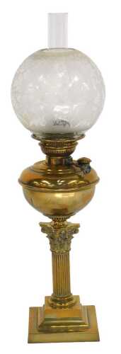 A Victorian brass Corinthian column oil lamp, with a frosted etched glass globular shade, above...