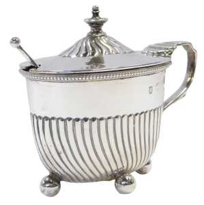 A Victorian silver lidded mustard pot, of semi fluted form, raised on four ball feet, with a...