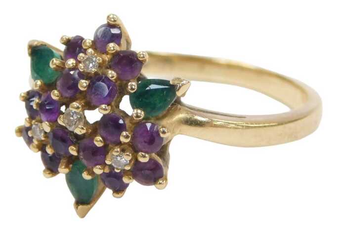An amethyst diamond and emerald dress ring, formed as four flowers with three petals, on a...