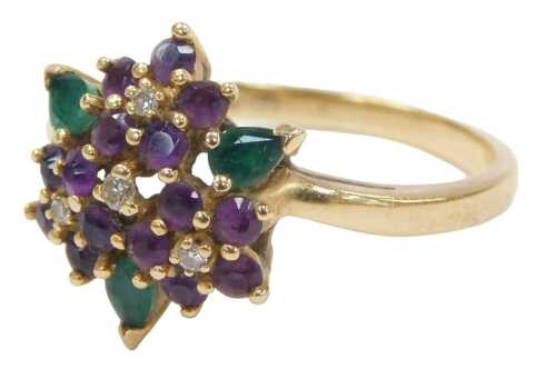 An amethyst diamond and emerald dress ring, formed as four flowers with three petals, on a...