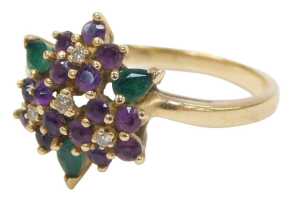 An amethyst diamond and emerald dress ring, formed as four flowers with three petals, on a...