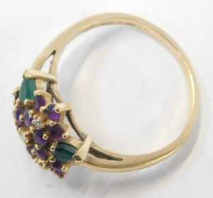 An amethyst diamond and emerald dress ring, formed as four flowers with three petals, on a... - 2