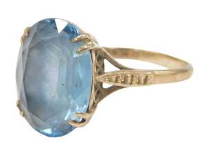 A blue zircon dress ring, the oval faceted stone in a double four claw setting, on a raised...