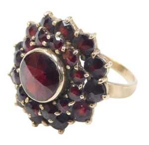 A 20thC garnet cluster ring, the central faceted garnet surrounded by twelve round brilliant cut...