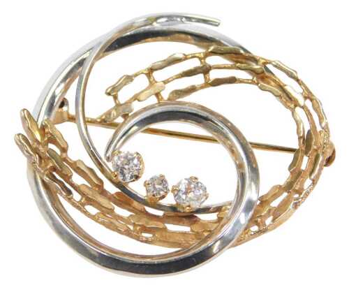 A 9ct white and yellow gold abstract brooch, formed as a swirl with pierced yellow gold and...