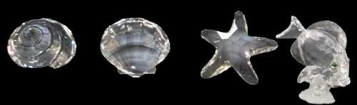 A group of Swarovski crystal, comprising a fish, a starfish, and two shells, each boxed.