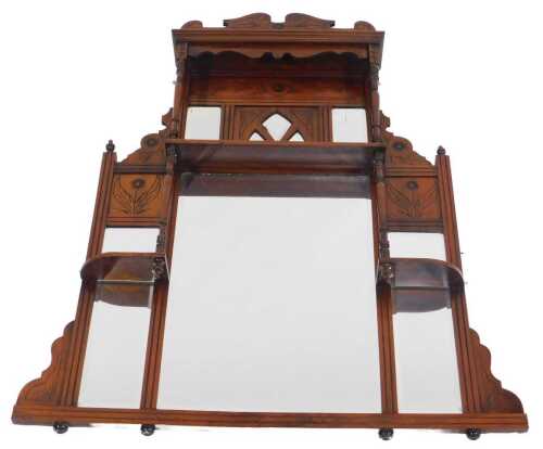 A late Victorian walnut overmantel mirror, the top with a scrolling and floral carved pediment...