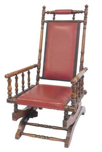 An early 20thC American walnut rocking chair, with overstuffed red leatherette seat and back,...