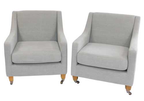 A pair of pale grey upholstered armchairs, raised on square beech legs, on front castors, 76cm...