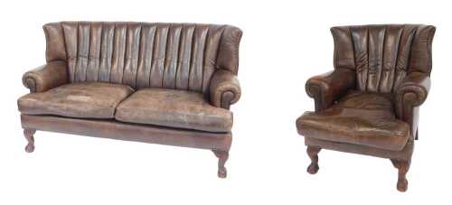 A club style wingback brown leatherette upholstered two seater sofa, raised on mahogany ball and...
