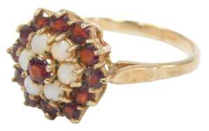 A 9ct gold cluster ring, set with garnets and opals, each concentric claw set in a raised basket,...