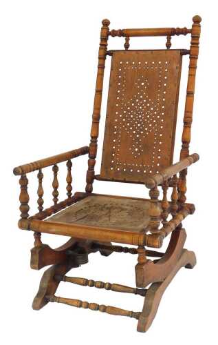 An early 20thC American beech rocking chair, with a solid pierced seat and back, raised on...