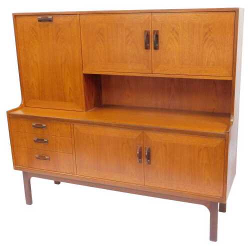 A G-Plan teak sideboard, the top with a fall flanked by two cupboards, the base with three...