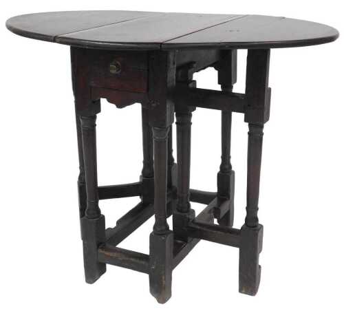 An 18thC oak oval gate leg table, on turned supports, 66cm high, 64cm wide, 27cm deep.