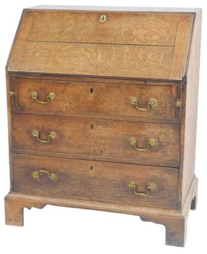 A 19thC oak bureau, the fall enclosing a single cupboard and an arrangement of drawers and...