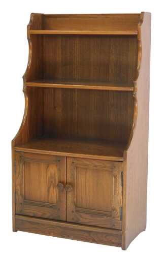 An Ercol Old Colonial elm waterfall bookcase, with two shelves, and two panelled cupboard doors...