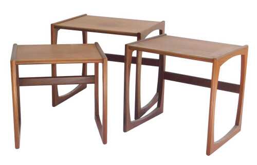 A nest of three 1970s teak tables, possibly G-Plan, raised on U shaped supports, the largest...
