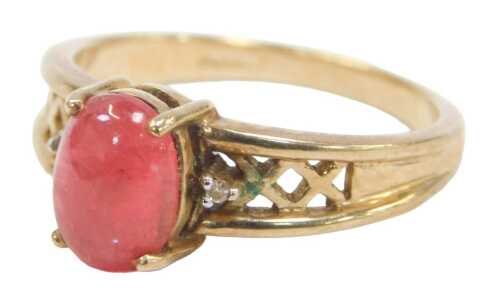 A 9ct gold and cabochon dress ring, the red cabochon in a raised basket with two tiny diamond...