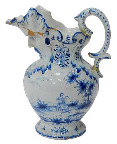 An 18thC Dutch tin glazed ewer, with a moulded mask spout, the body decorated with a figure in...