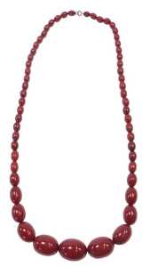 A graduated cherry amber necklace, of fifty seven beads, the largest 3.5cm wide, the smallest...