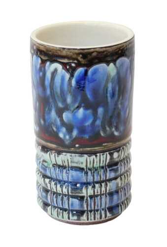 A Poole pottery cylindrical vase, decorated in shades of blue, green, brown and red, the bottom...