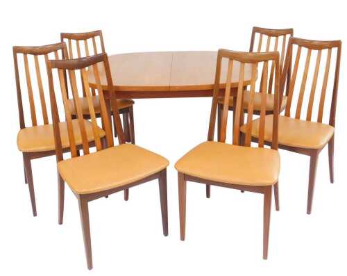 A 1970s G-Plan teak extending dining table, the top with a rounded edge with draw leaf mechanism,...